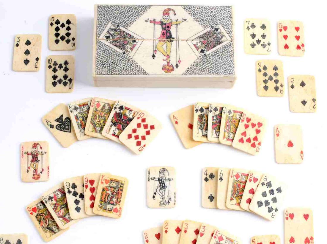 SCHRIMSHAWED BONE MINIATURE PLAYING CARDS W CASE: Total of 51 miniature antique poker playing cards in a 4 1/4 x 2 1/4 x 1 inch case with a decoratively carved top. Chip on lower corner border and loss to one hinge along inside age.