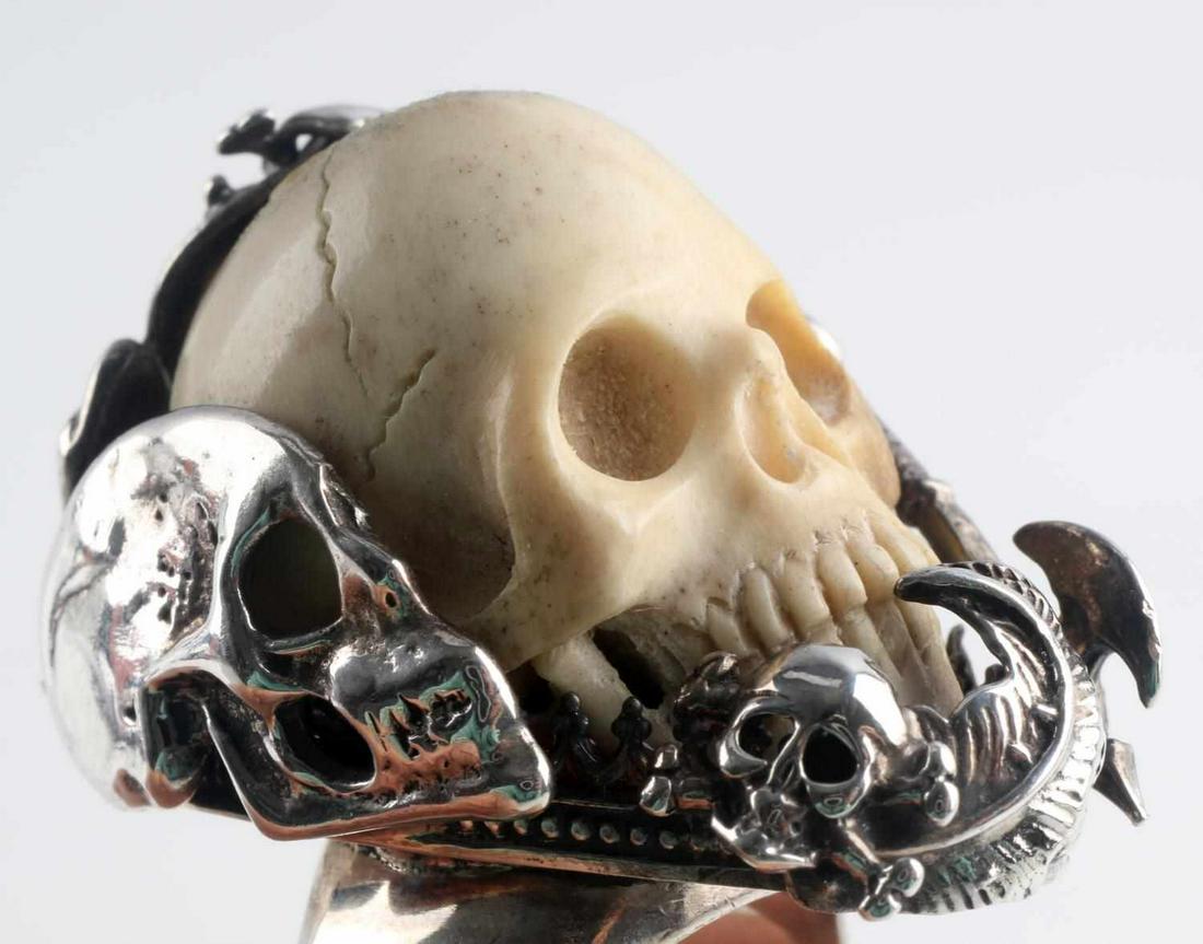 STERLING SILVER TAXCO CARVED BONE SKULL RING: Sterling silver ring marked Sterling TR-147, detailed silversmith work featuring skulls, cross bones, a snake, a pirate sword and a battle axe around a highly detailed carved skull made of bone. Uniqu