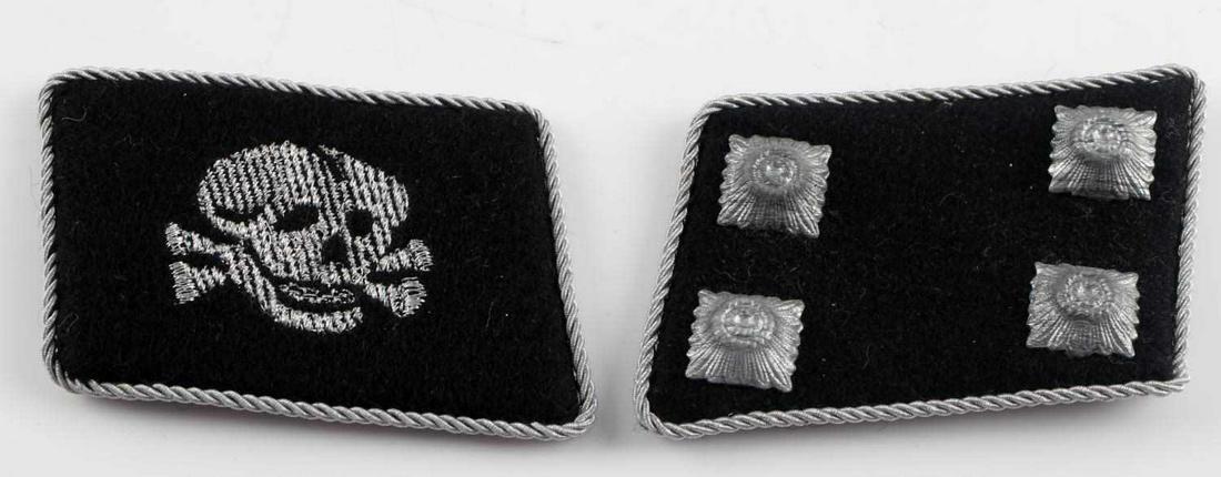 2 WWII THIRD REICH SS OFFICER TOTENKOPF COLLAR TAB: Pair of German WWII Waffen SS Totenkopf Officers Collar Tabs. The measure 1 11/16” wide by 2 7/16” tall. The first collar tab shows a flat wire skull and cross bones with the jaw. The second colla