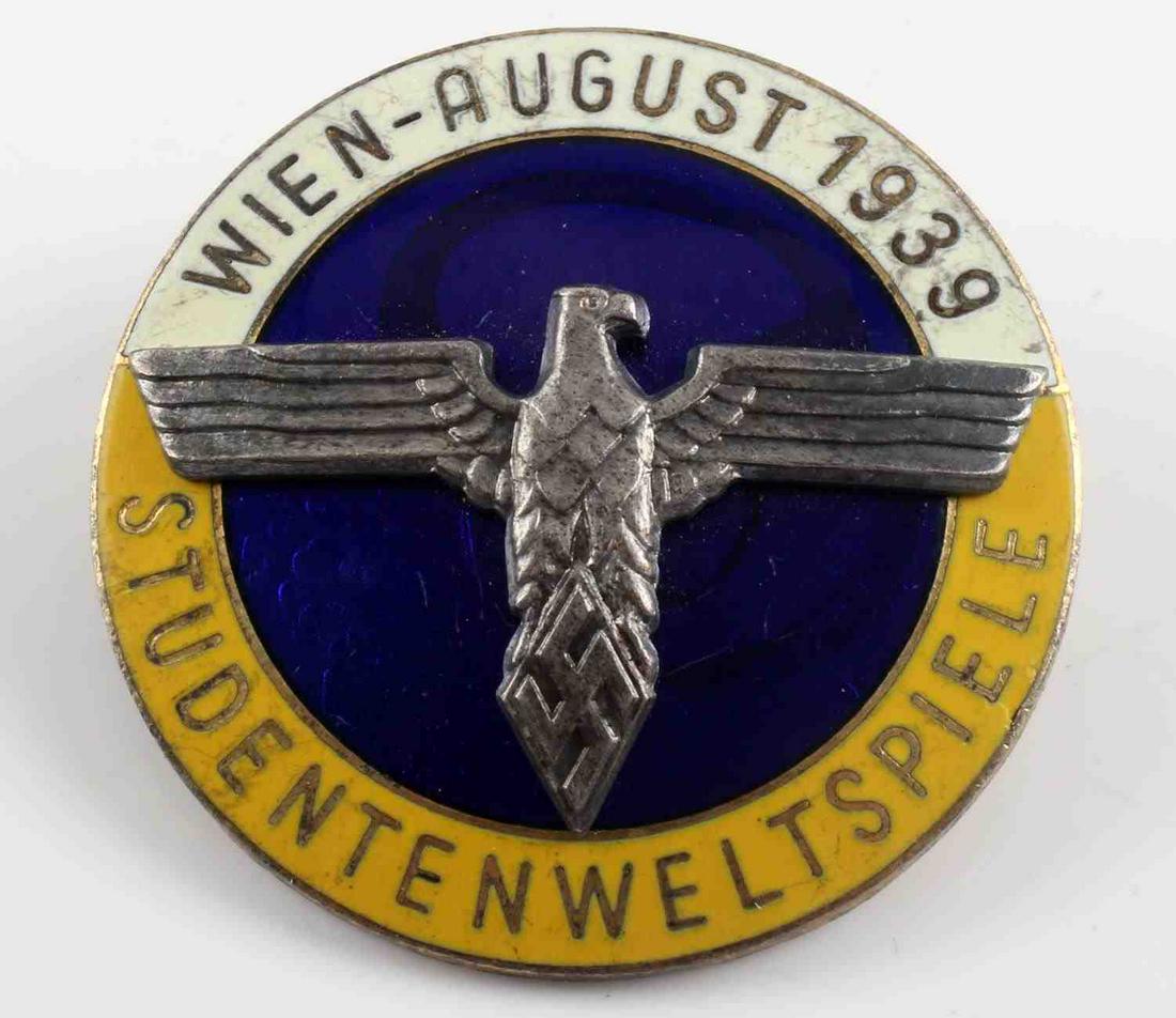 WWII THIRD REICH STUDENTENWLTSPIELE BUND BADGE: German WWII Wien August 1939 Studentenweltspiele Bund Badge. The front reads ‘Wien – August 1939 Studentenweltspiele’. There is a German eagle clutching a swastika in his talons. Measures 1 9/16