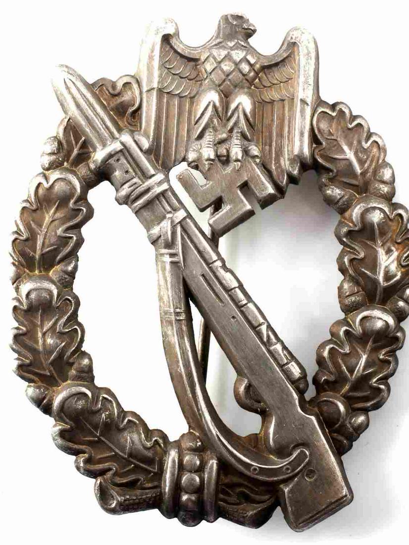 WWII GERMAN THIRD REICH INFANTRY ASSUALT BADGE: German World War II Army Silver Infantry Assault Badge. The front shows a Mauser K-98 rifle in the center with a German Army eagle at the top. Both are surrounded by an oval oak leaf wreath. Has a thi