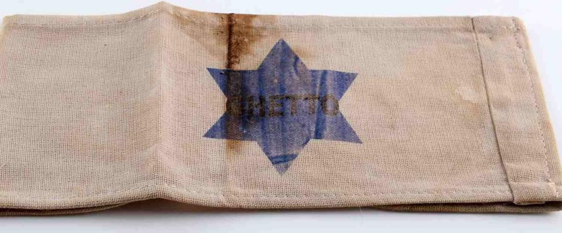 WWII THIRD REICH JEWISH CONCENTRATION CAMP ARMBAND: German WWII Jewish Star Concentration Camp Arm Band. Measures 8 3/4” wide by 3 3/4” tall. The front shows a blue Jewish star in the center. One piece machine sewn printed cotton construction. Unau