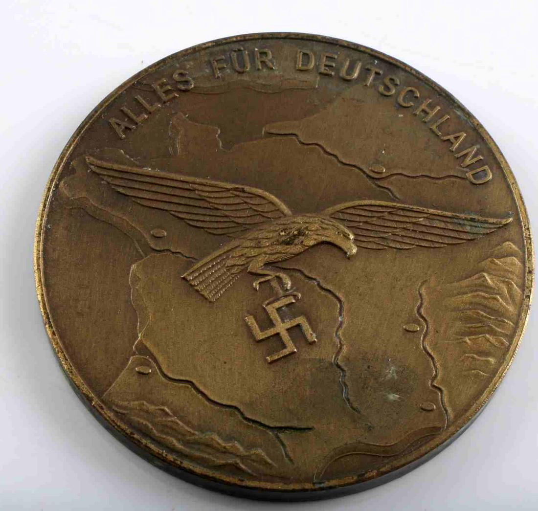 WWII GERMAN THIRD REICH LUFTWAFFE TABLE MEDAL: German WWII Luftwaffe Alles Fur Deutschland Table Medal. Measures 1 5/8” in diameter. The front shows a Luftwaffe flying eagle clutching a swastika in his talons in the center. It reads ‘Alles Fur