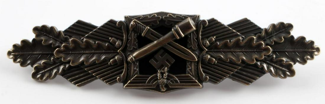 WWII GERMAN THIRD REICH BRONZE CLOSE COMBAT CLASP: WWII German Army Bronze Close Combat Clasp. The front shows an army eagle with a crossed stick grenade and bayonet below. All three are flanked by oak leaves on each side. The reverse is maker marked 