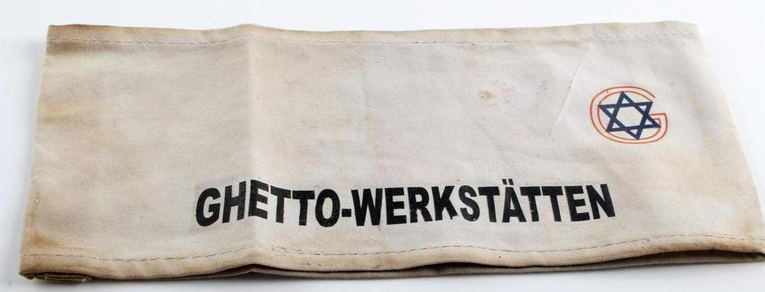 WWII THIRD REICH JEWISH GHETTO WERKSTATTEN ARMBAND: German WWII Jewish GHETTO WERKSTATTEN Concentration Camp Arm Band. Measures 9 3/16” wide by 3 3/4” tall. The front shows a Jewish star in the upper right handle. It reads ‘GHETTO WERKSTATTEN’.
