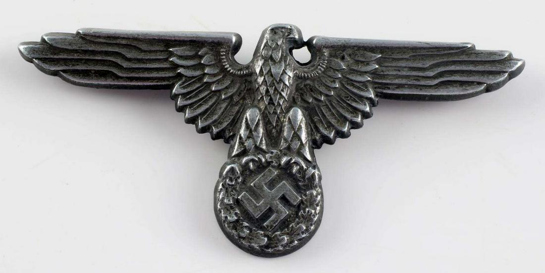 WWII GERMAN THIRD REICH SS OFFICER VISOR EAGLE: German World War II Waffen SS Officers Visor Cap Eagle. Measures 2 3/4 x 1 1/4 inches. The front shows the Waffen SS eagle clutching a swastika in his talons. The reverse side is maker marked ‘ES PF