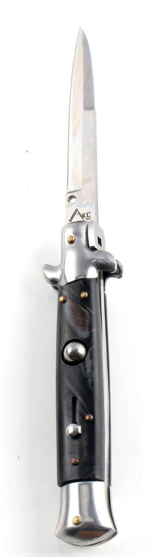 AKC ITALIAN SWING GUARD STILETTO SWITCHBLADE KNIFE: AKC Italian swing guard stiletto switchblade knife. "AKC Italy" stamped on the blade. Features a black handle and a locking mechanism. Measures 9 inches open, 5 inches closed. Very good condition over