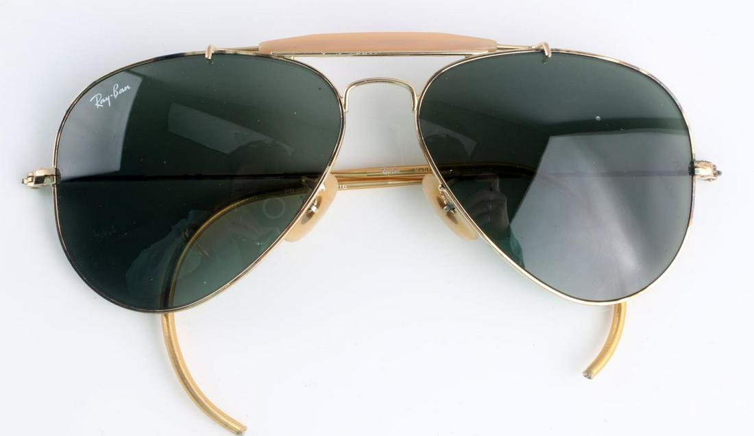 1970'S VINTAGE RAY BAN AVIATOR SUNGLASSES: Vintage Ray Ban Aviator sunglasses, gold and champagne accents with green tinted lenses, left lens has a 1mm chip, it is not noticeable to the wearer while on, does not impede vision. Otherwise in ver