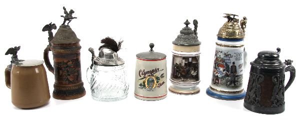 MIXED LOT OF GERMAN BEER STEINS: Lot to include: A wood bodied stein of 6 inches with dragon motif in white metal. A stonewear Olympia Beer stein and another similar with eagle topped lid (5 inches tall), the second one with old crac