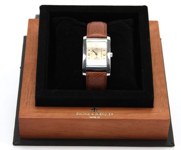BAUME & MERCIER MENS DRESS WATCH: Rectangular dial in stainless and gold tone. With brown leather band. Second hand. In original box, worn very few times.