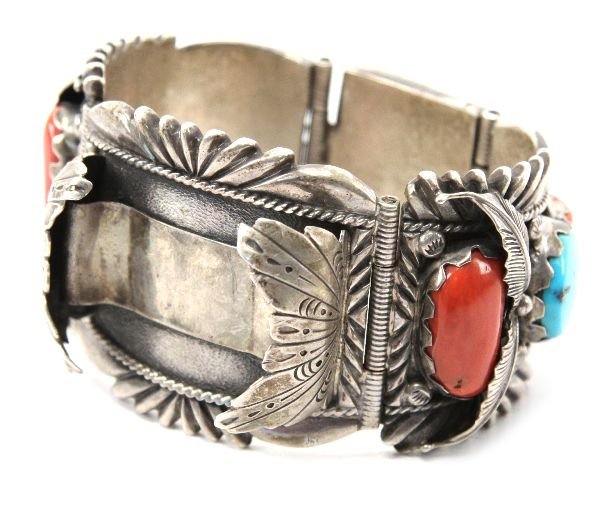 HEAVY STERLING SILVER NAVAJO WRISTBAND WATCH STRAP: A heavy sterling silver bracelet decorated with turquoise and coral. Signed by "RW James". Total weight 183g.