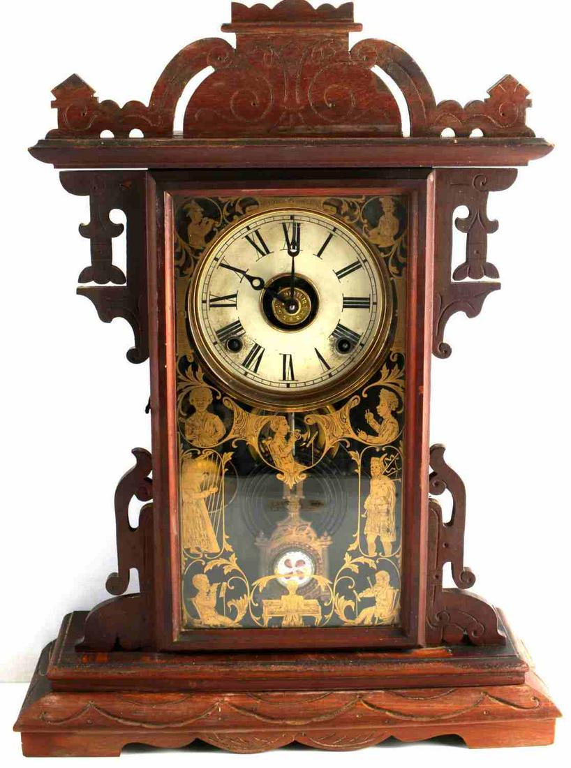 19TH CENTURY CARVED WOOD ANTIQUE SHELF CLOCK: Working (may need servicing) antique shelf clock with keys. Hand carved with ethnic musical motif in gold leaf accents on front glass panel. Dimensions: 22x16x5 1/2 inches.