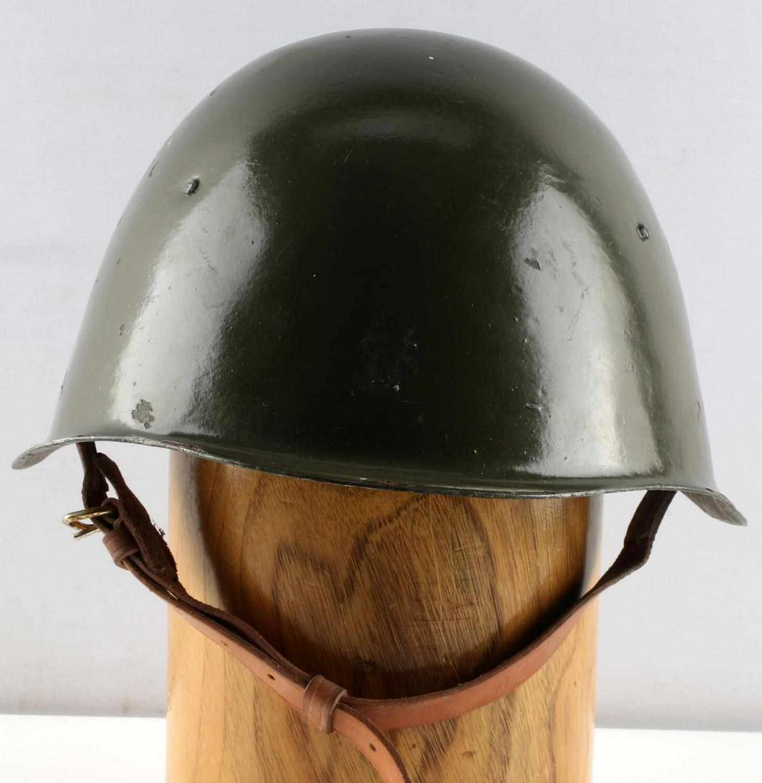 POST WAR POLISH MADE COMBAT HELMET KZWM: KZWM - Kieleckie Zaklady Wyrobów Metalowych, factory in Kielce, Poland. KZWM 1968 stamp to interior. 8 finger leather liner and chinstrap. Front to back inside measures 8 inches. Very good condition.