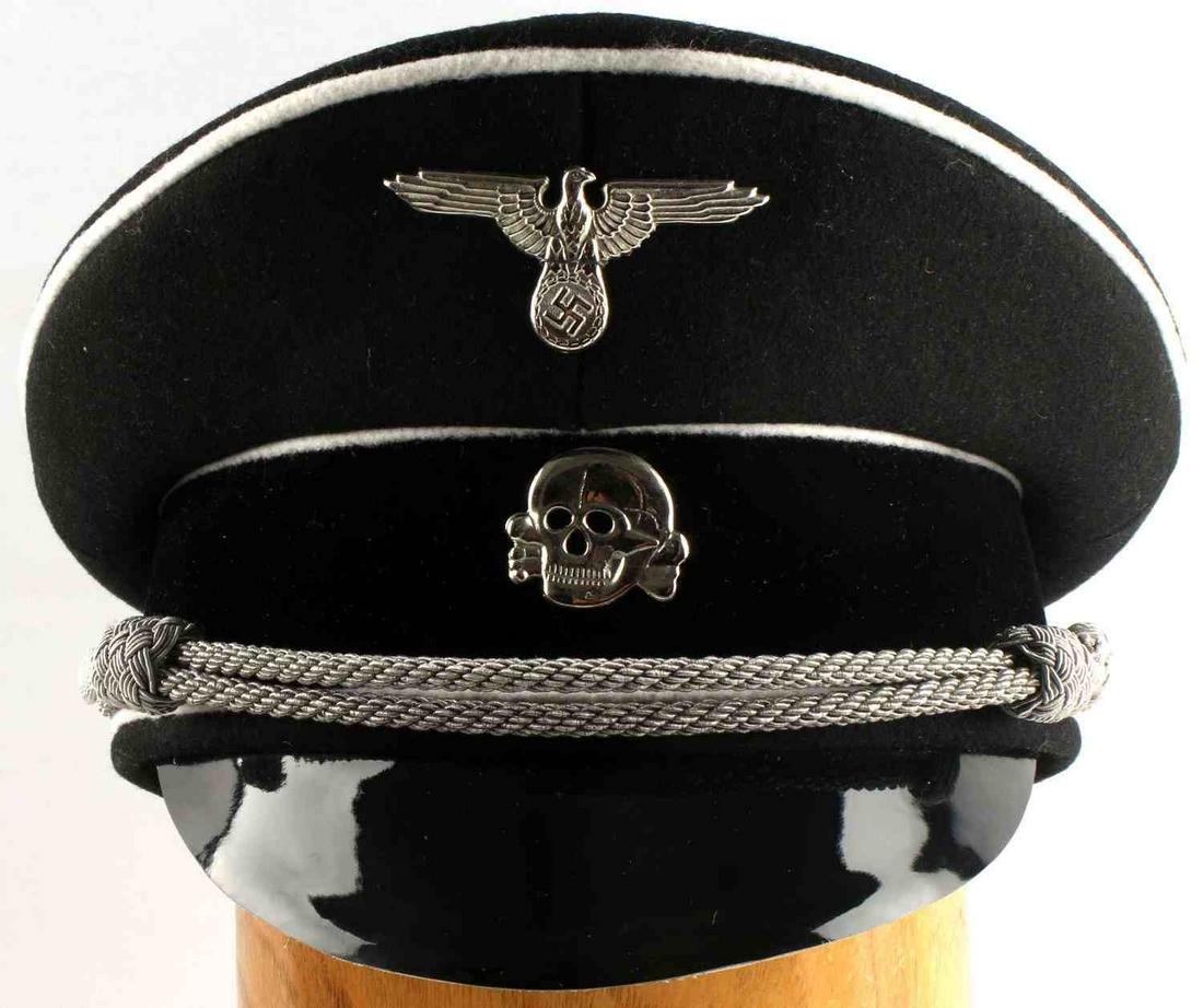 WWII GERMAN WAFFEN SS OFFICERS VISOR HAT CAP: Black wool cap with grey piping, silver bullion chinstrap, and eagle and Totenkopf insignia. SS and 57 label to interior. Very good condition. Unauthenticated, sold as is. This lot has a reserve.