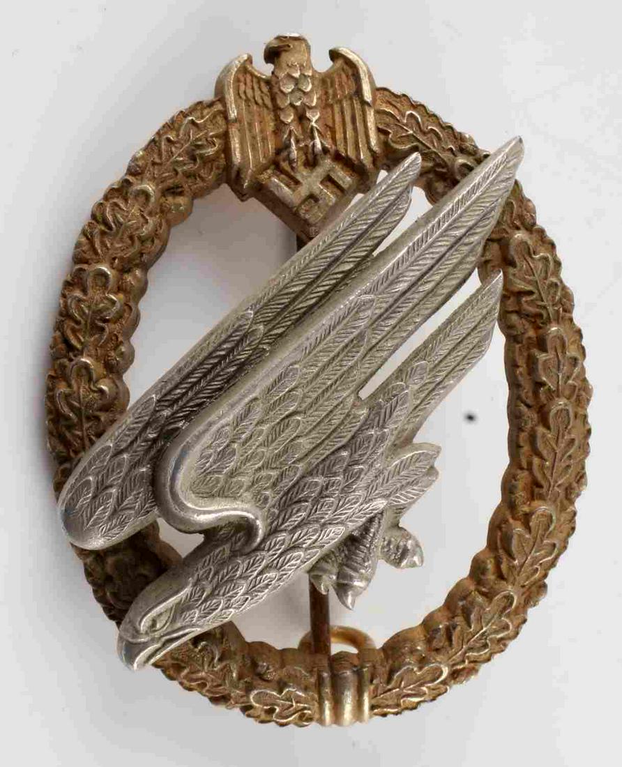 WWII GERMAN REICH LUFTWAFFE PARATROOPER BADGE: Third Reich Luftwaffe paratrooper badge. Features diving eagle surrounded by oak leaves. Reverse marked C.E. Junker Berlin S.W. High domed rivet construction with most gilding remaining. Measures 2 in