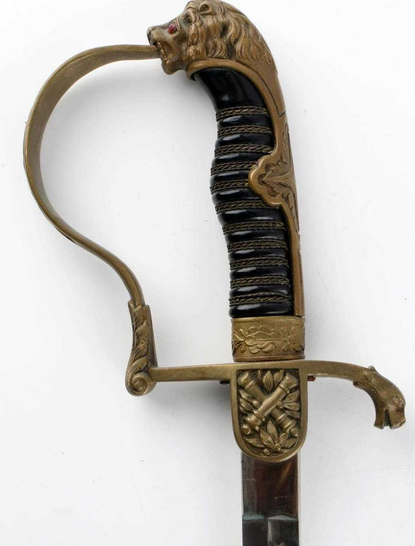 WWI IMPERIAL GERMAN LION HEAD ARTILLERY SWORD: Very good blade and dent free scabbard, missing one eye stone, wire wrapped Bakelite grip, brass D guard,