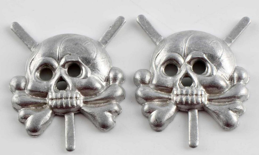 LOT OF 2 WWII GERMAN ARMY PANZER CORPS TAB SKULLS: Lot of 2 WWII German Army Panzer Tank Corps collar tab skulls. The dimensions are 15/16 X 2 3/16 tall. The front shows a jawless skull and cross bones. There are three flat prongs for attaching to the