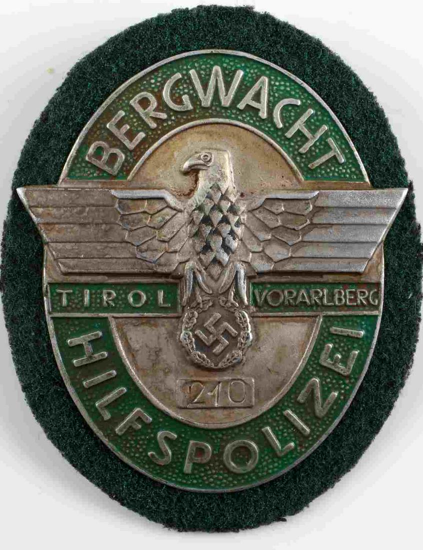 GERMAN WWII THIRD REICH TIROL POLICE SHIELD PATCH: German WWII Tirol Mountain Police Shield Patch. Green patch with metal finish on letters. "Bergwacht" across top of shield. "Hilfspolizei" across bottom of shield. no. 210. In good condition. Measures