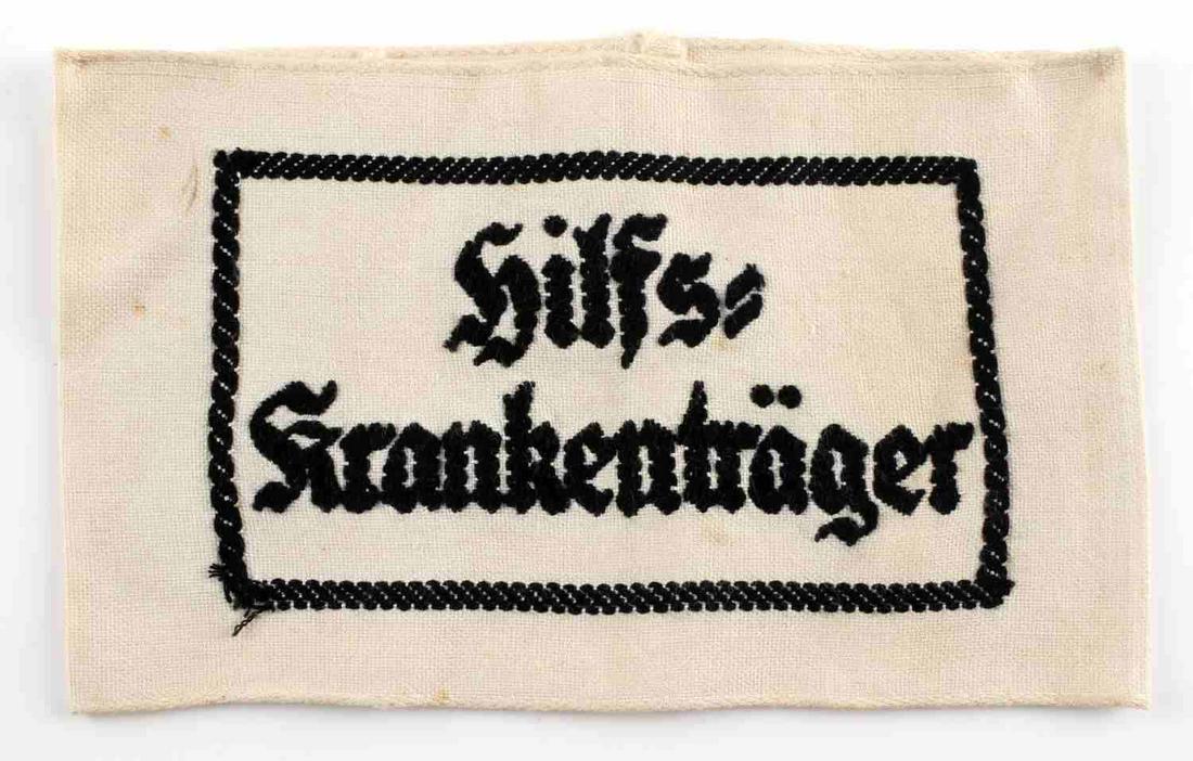 WWII GERMAN REICH HILFS HEER STRETCHER BEARER BAND: WWII German Reich Heer Hilfs Krankentrager medical stretcher bearer armband measuring 6 11/16 inches wide and 4 inches tall from the front. Design and lettering has been stitched. In good condition, d