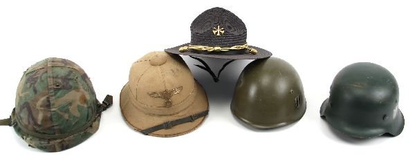 MIXED LOT OF MILITARY HELMETS: To include: A US "Vietnam" era helmet. A WWII Italian helmet with spurious Italian and SS decals, A refurbished M42 German helmet. A German tropical type helmet with badge. A "smoky bear" hat.