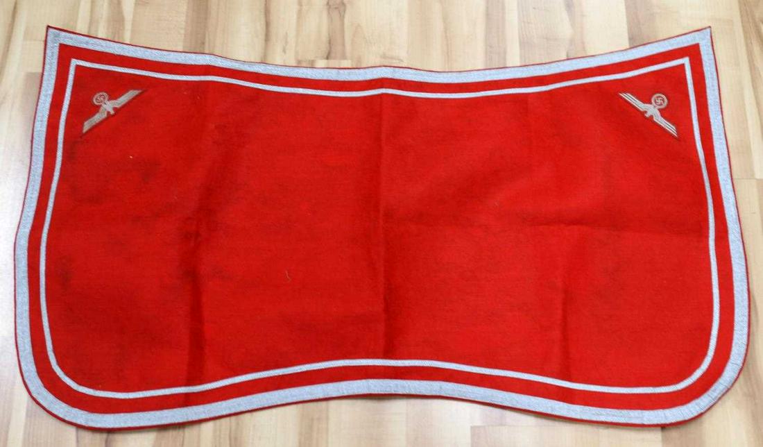 WWII GERMAN WEHRMACHT PARADE SADDLE BLANKET: WWII German parade saddle blanket for Wehrmacht artillery units. Red saddle blanket with double silver piping around the edge with a Reichsadler to the squared corners. Does not fluoresce. 46 X 25 inc