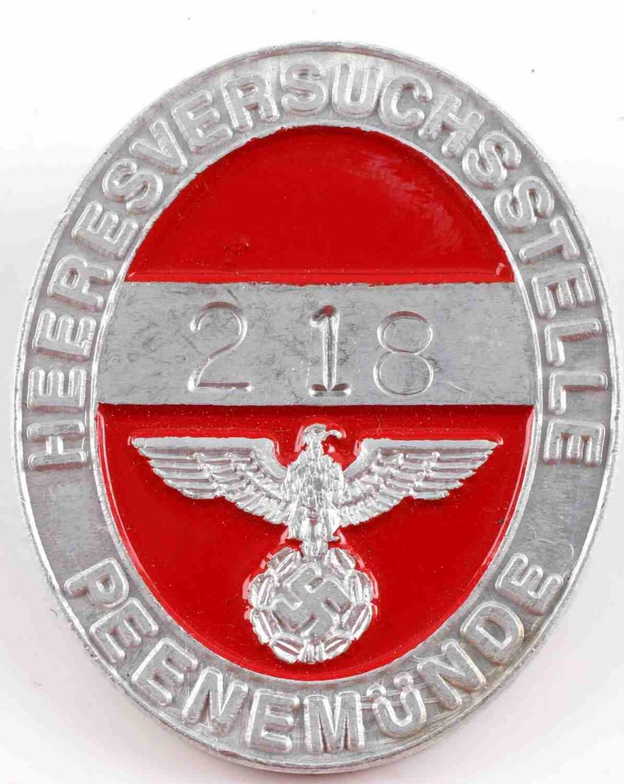POST WWII PROD GERMAN PEENEMUNDE V2 WORKER BADGE: Post WWII production Third Reich peenemunde V-2 worker badge. Numbered 218. Red enamel on aluminum. Good condition. 1 3/4 inches.