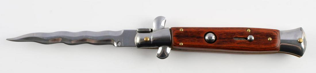 9 3/4 INCH STILETTO LIKE SWITCHBLADE KNIFE: Stiletto-like switchblade knife. 9 3/4 inches open. Rose wood-like grip. Kris stainless blade made in China. Very good condition.