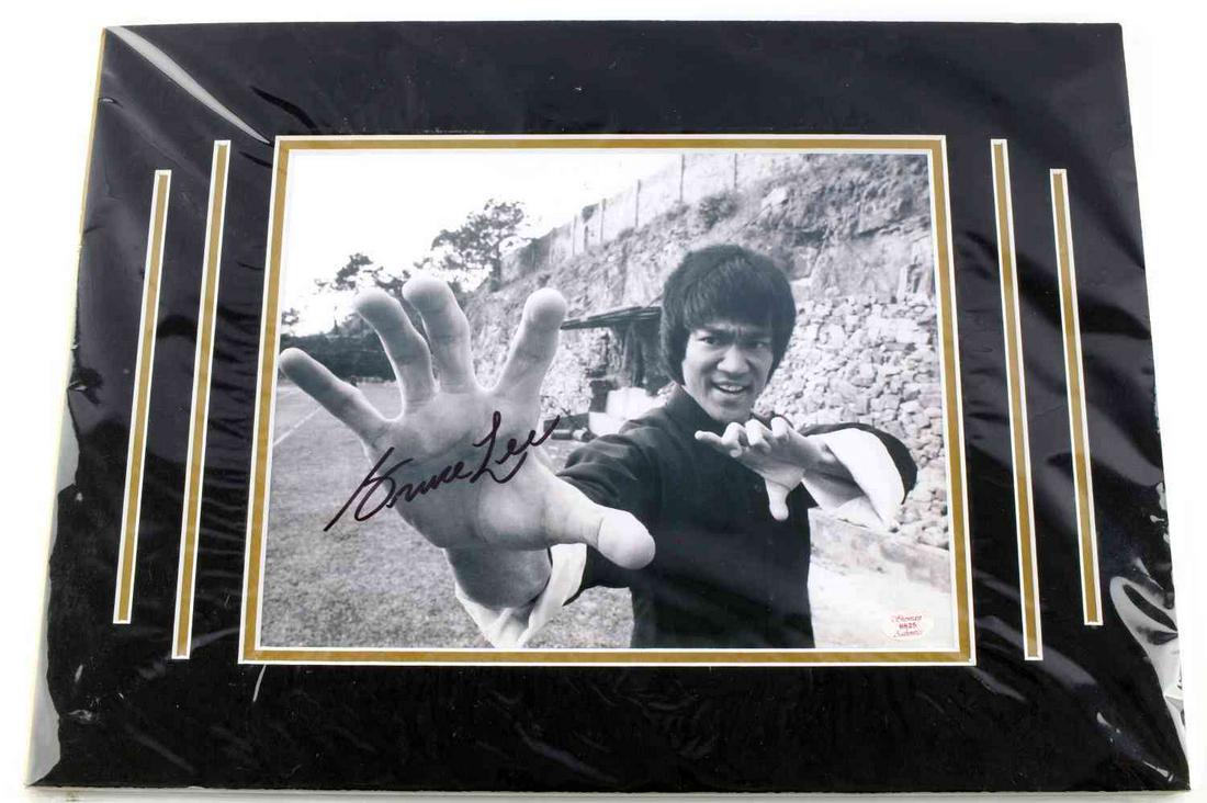 8 X 10 BRUCE LEE SIGNED PHOTOGRAPH: Signed photograph of Bruce Lee. Black marker signature to Bruce Lee's palm. CoA from Showcase Authentics included.