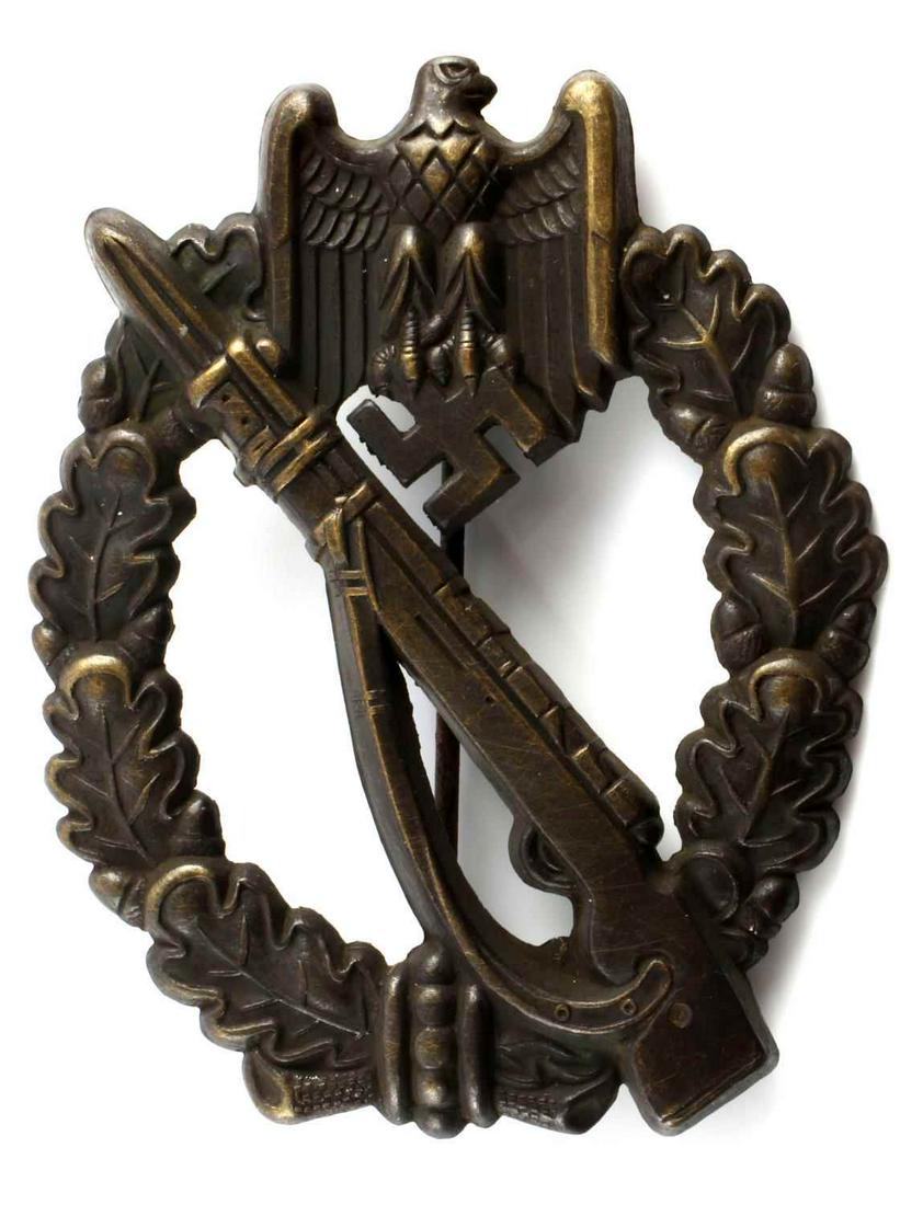 WWII THIRD REICH GERMAN INFANTRY ASSSAULT BADGE: German WWII Army Bronze Infantry Assault Badge. Obverse features Mauser K 98 rifle in the center with Reichsadler above surrounded by an oval oak leaf wreath. Thin vertical pin back with a ‘c’ cat