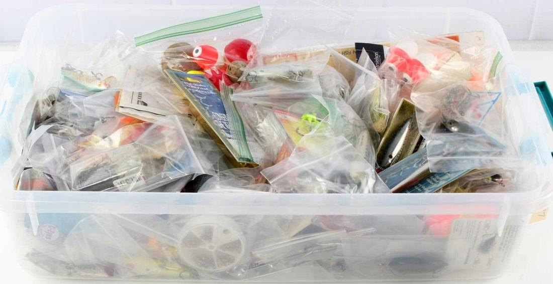UNSEARCHED BOX OF FISHING LURES BOBBERS HOOKS FLY: Large unsearched container of Saltwater and freshwater gear, noted upon brief review antique wood lures with glass eyes, modern lures, used and unopened newer and vintage hooks, bobbers, sinkers, flie