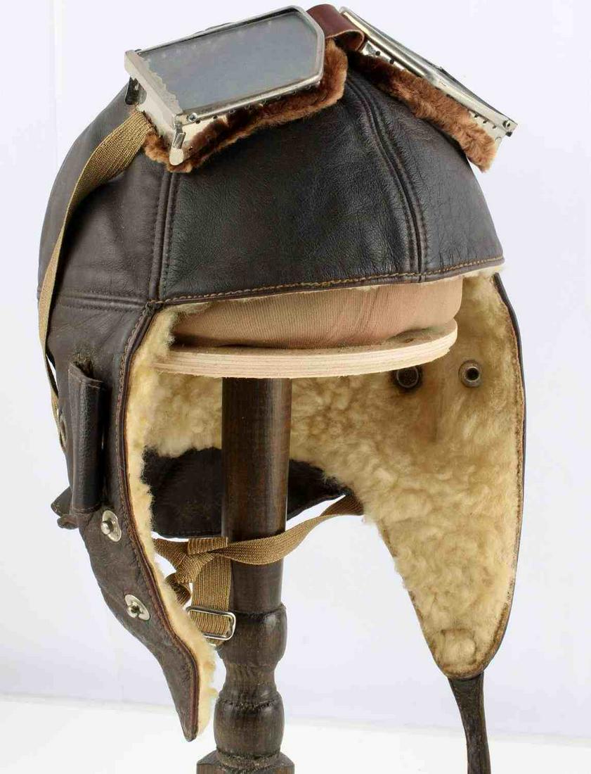 WWI IMPERIAL GERMAN FLIGHT HELMET W GOGGLES: WWI Imperial German flight helmet with goggles. Typical German Air Service flying helmet in soft brown leather lined with wool. It features small roll back ear pieces that can be press-studded open or