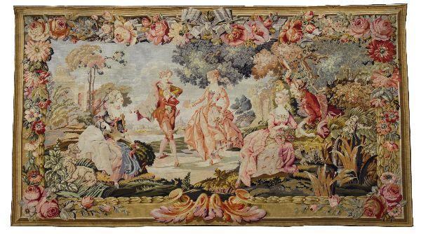 LARGE AUBUSSON STYLE NINETEENTH CENTURY TAPESTRY: A floral and ribbon boarder frame surrounds a depiction of an 18th century musical romp on the estate grounds. Central figures are accompanied by flora and fauna. Wonderful texture is achieved by smal