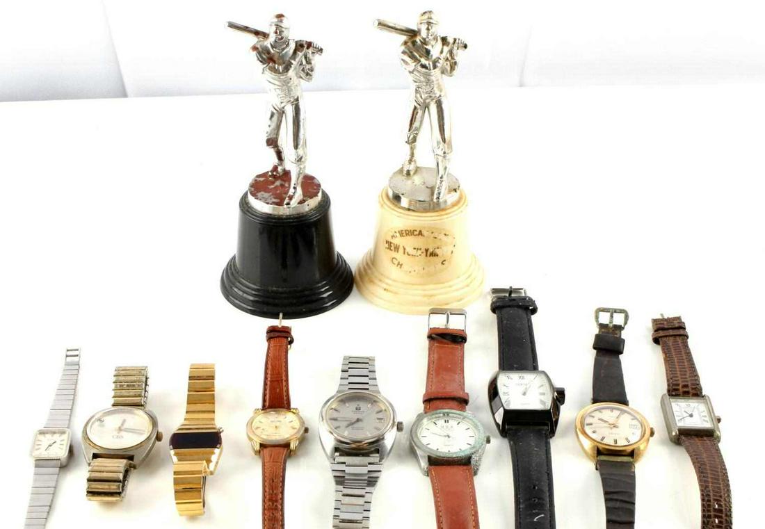 LOT OF 9 WATCHES 2 TROPHIES TOSSIT RONDA WATCH: Lot includes; 9 watches with varying brands; Tissot (band broken scratch on crystal), Terner (band worn), Timex (band worn buckle oxidized), Ronda (crystal scratched), and more. 2 plastic baseball tro