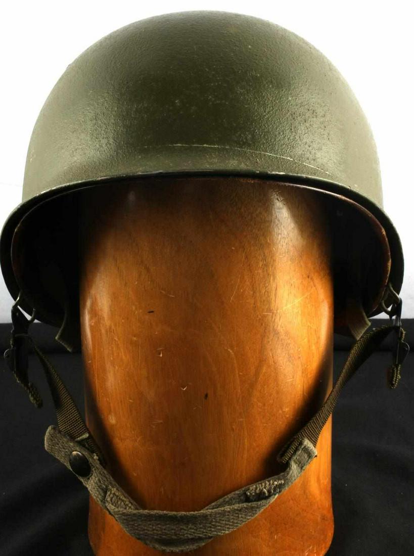 WWII U.S. MILITARY M1 COMBAT HELMET WITH LINER: Green steel helmet with canvas and leather liner. No markings. Interior is marked "Will Kelso". Metal snap clasp chin straps. Very good condition. Measures 11 X 9 inches across.