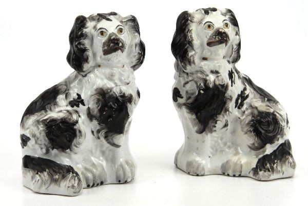 PAIR OF STAFFORDSHIRE POTTERY DOGS: A mirrored pair of Staffordshire dogs standing 5.5 inches tall. With typical black and white hand painting spots and yellow to eyes.