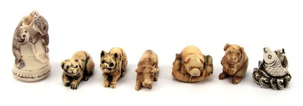 GROUP OF SEVEN CARVED ZOOMORPHIC IVORY NETSUKE: A collection of seven carved netsuke animals, including (2) signed carved ivory crouching dogs, an ivory groundhog on hind legs, an ivory reclining ox, a signed ivory auspicious double fish symbol, a 