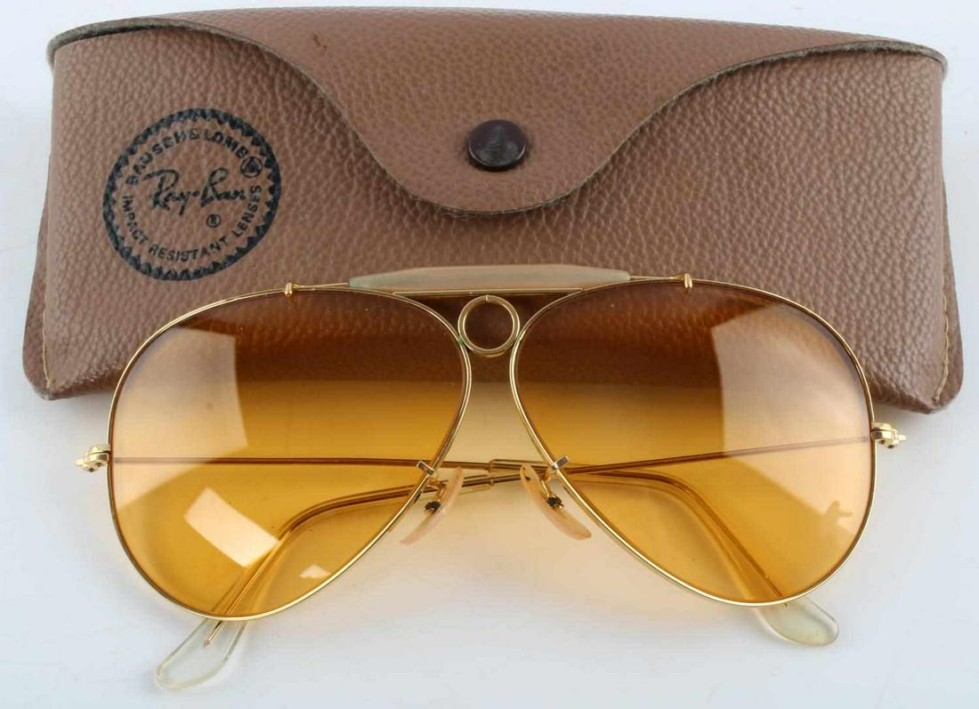 VINTAGE BAUSCH & LOMB RAY-BAN AVIATOR SUNGLASSES: Yellow tint, extremely minimal scratching to lenses. Adjustable nose pieces. Come in original leather case. Scuffing to earpiece but overall good condition. This lot has a reserve.