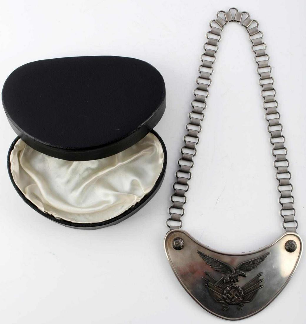 WWII GERMAN THIRD REICH LUFTWAFFE STANDARD GORGET: WWII German Third Reich Luftwaffe standard gorget. Features Luftwaffe eagle clutching swastika with flags. Reverse marked C.E. Juncker Berlin. Measures 6 3/4 inches. Chain measures approximately 24 in