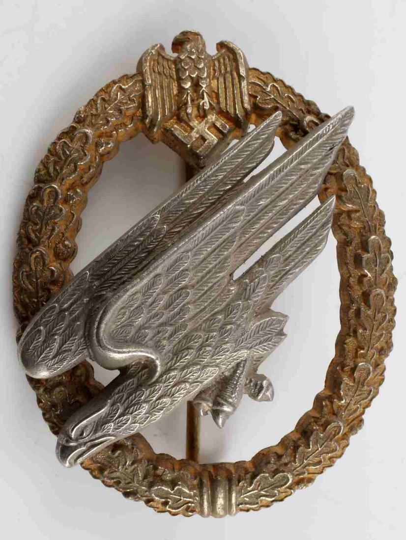 WWII THIRD REICH LUFTWAFFE PARATROOPER BADGE: German Third Reich Luftwaffe Paratrooper badge. Wartime zinc wreath. C.E. Junker Berlin S.W. Measures 2 1/4 inches. Thin vertical pin with C catch. Very good condition. This lot has a reserve.