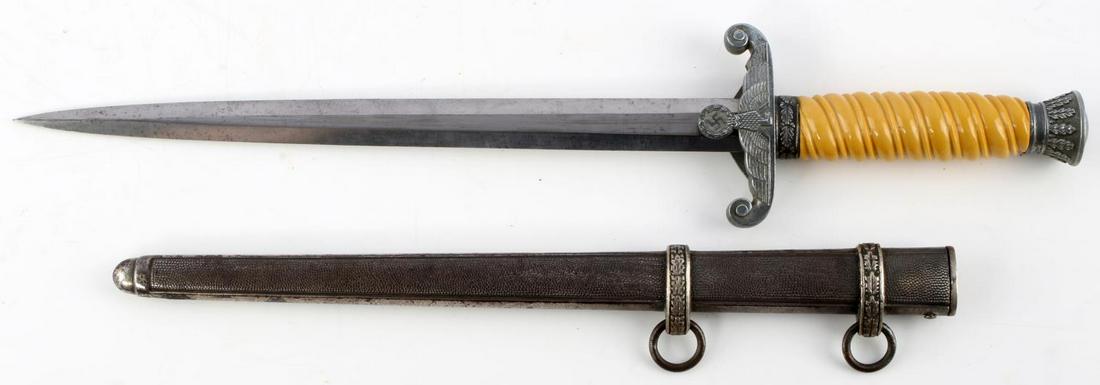 WWII GERMAN HEER OFFICER'S DAGGER WITH SCABBARD: WWII German Heer Officer's dagger with scabbard. Nickel pommel and crossguard featuring an oak leaf design and a Reichsadler to the crossguard. Yellow celluloid grip. Unmarked blade with very light pi