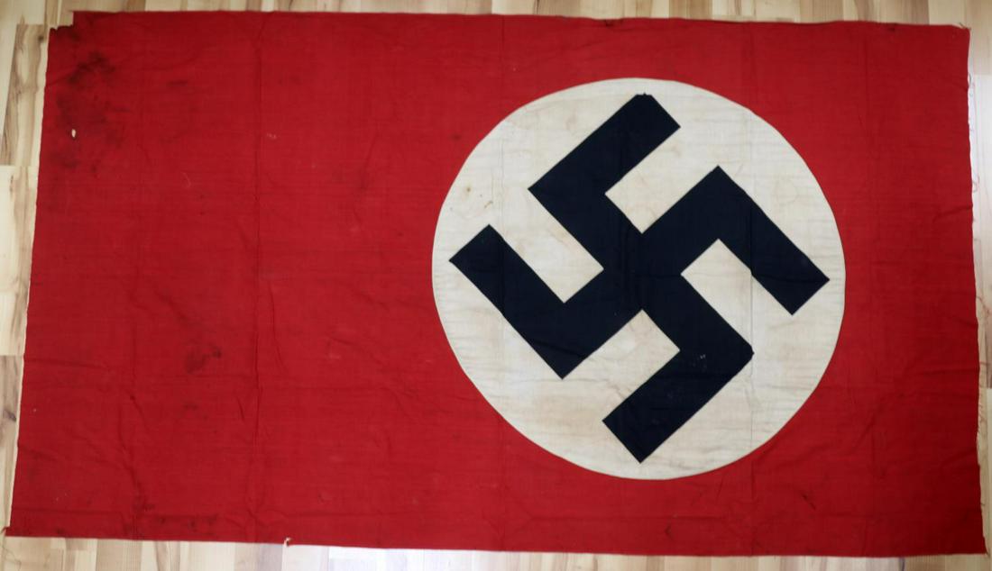 WWII GERMAN THIRD REICH NATIONAL PARTY FLAG: Third Reich flag with national party symbol. Cotton construction. Measures 78 1/4 X 44 1/2 inches. Very good condition with mothing and some discoloration.