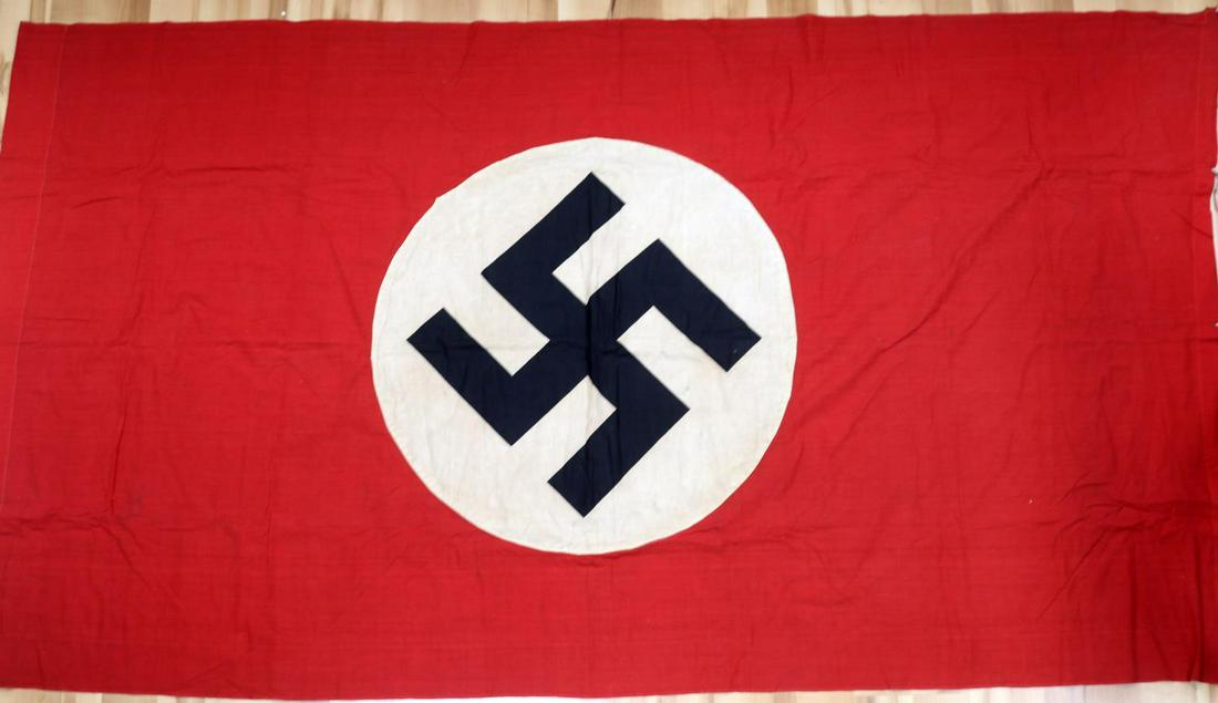 WWII GERMAN THIRD REICH NATIONAL PARTY FLAG: Third Reich national party flag. Multipiece construction with printed swastika. Measures 87 X 46 inches. Very good condition with discoloration. Non-fluorescing.
