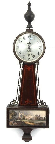 KEY WIND SESSIONS EIGHT DAY BANJO CLOCK: Sessions "Provincetown" banjo clock, 25 inches overall. Solid Mahogany case with original finish and original sticker affixed to verso. Abbey motif on door. Brushed nickel finish to dial with Arabic n