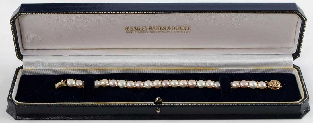 7.07MM TRI-COLORED COIN PEARL YELLOW GOLD BRACELET: Pearls are 7.07 millimeters (average) wide and 4.71 millimeters thick. The pearls are strung on two threads of cotton and are in sequences of white, pink and lilac. Each pearl has two 1.92 millimeter 