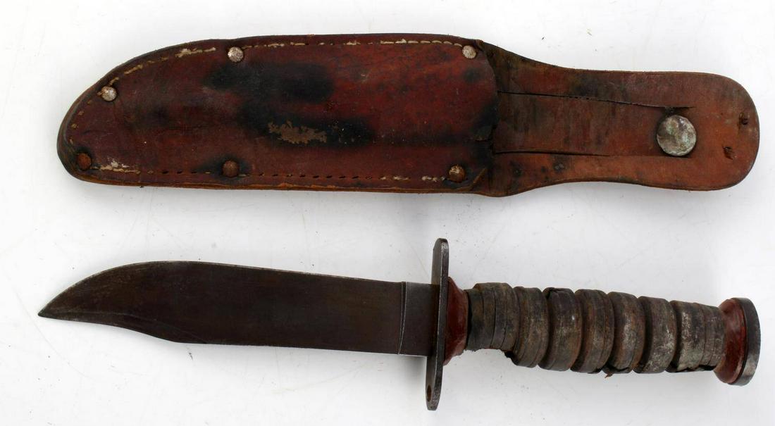 SCHRADE WALDEN FIGHTING KNIFE WITH LEATHER SHEATH: Fixed blade knife with a 5.25 inch blade, marked at ricasso, steel guard, bakelite collar, and wood ringed grip with much loss, leather sheath included.