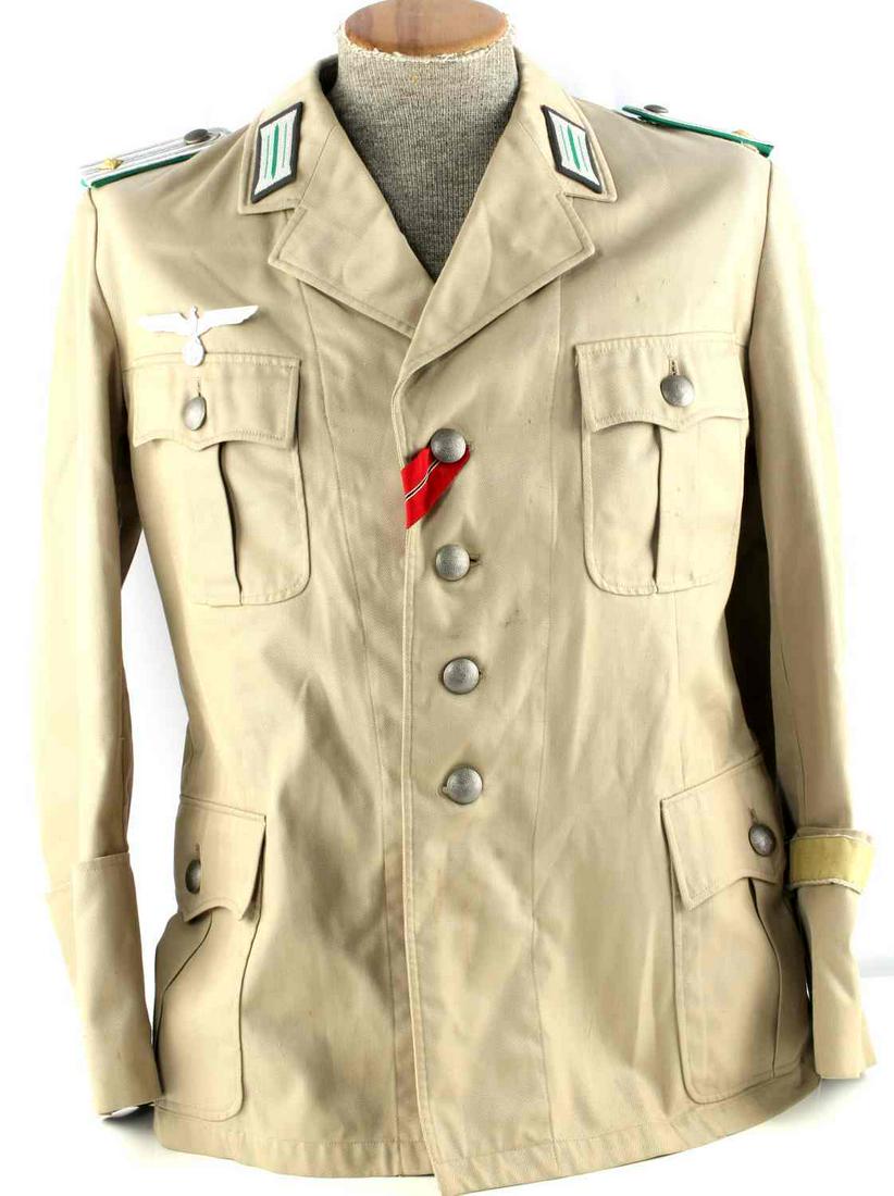 WWII GERMAN AFRIKA MOUNTAIN OFFICER TUNIC JACKET: Beige cotton tunic with silver and green shoulder boards, major rank, collar tabs, eagle insignia to right breast, red ribbon to top button, and cuff title on left wrist. Armpit to armpit measures 19.