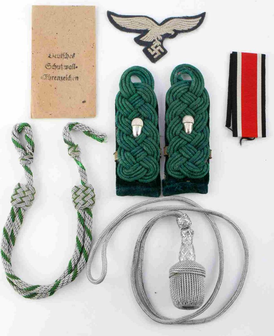 7 WWII GERMAN REICH PATCHES RIBBON PORTEPEE: Lot features a pair of shoulder boards, a Luftwaffe patch, an Iron Cross ribbon, a portepee, visor chin strap, and an award envelope. Measurements range 3 1/2 - 18 1/2 inches. Portepee fluoresces. Ver