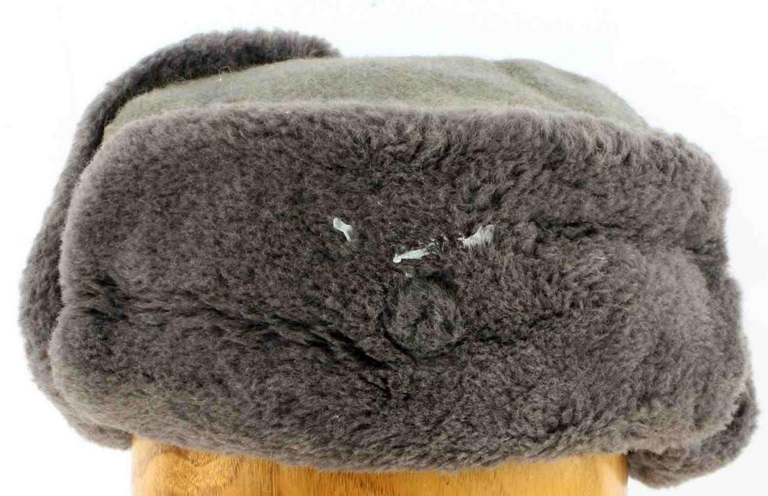 POST WAR WWII EAST GERMAN WINTER CAP HAT: Grey wool cap with cotton interior and faux fur exterior, NVA label to inside. Size 53. Glue residue to front. Good condition. Unauthenticated, sold as is.