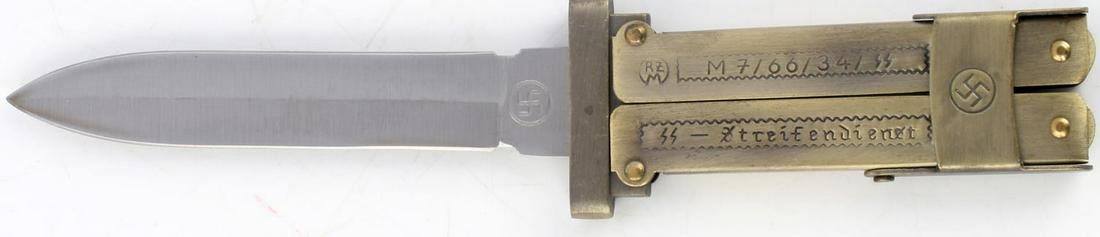 WWII THIRD REICH GERMAN PARATROOPER KNIFE: Folding knife with just under 4 inch blade, marked Stainless China to one side and swastika to other. Brass tone with numbers and title etched to handle. When closed, measures just under 6 inches long