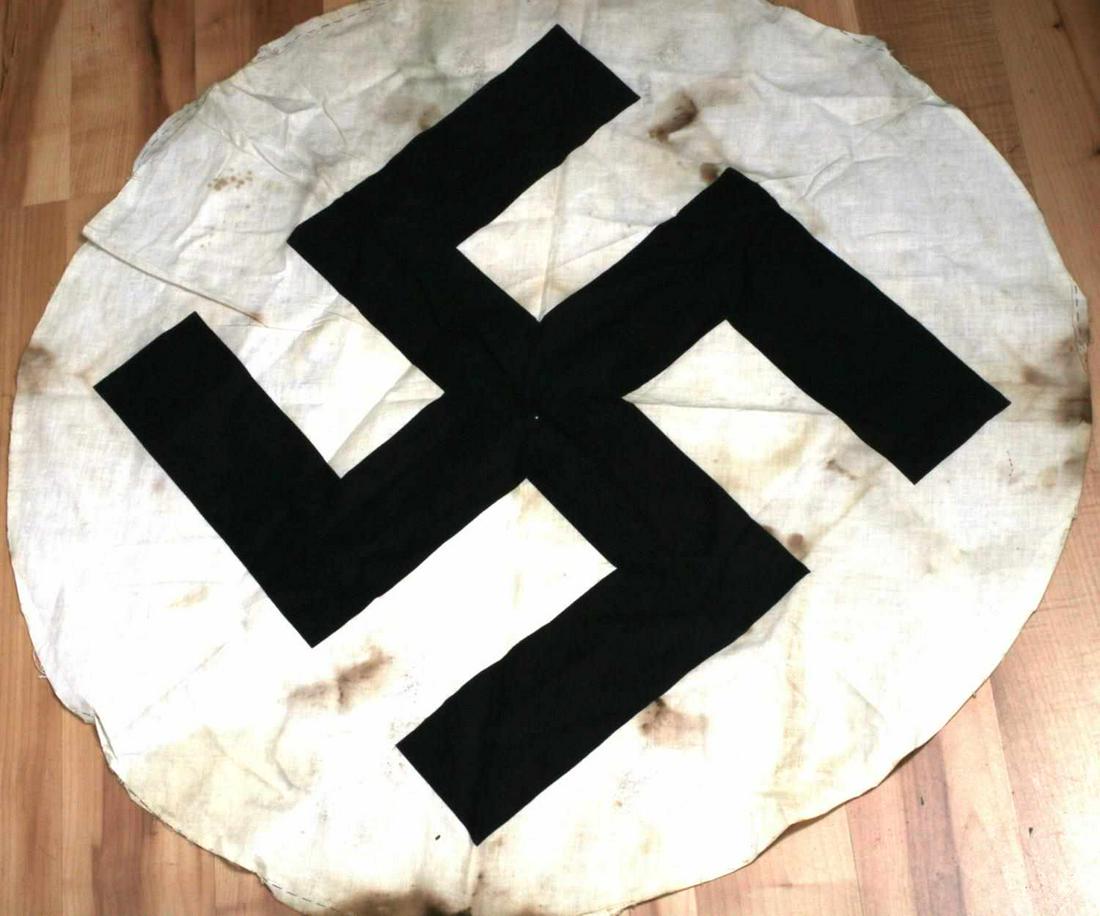 WWII GERMAN THIRD REICH PARTY FLAG ROUNDEL: Roundel for a Third Reich flag. White with black party symbol. Measures 28 inches in diameter. Good condition with some tearing and staining. Non-fluorescing.
